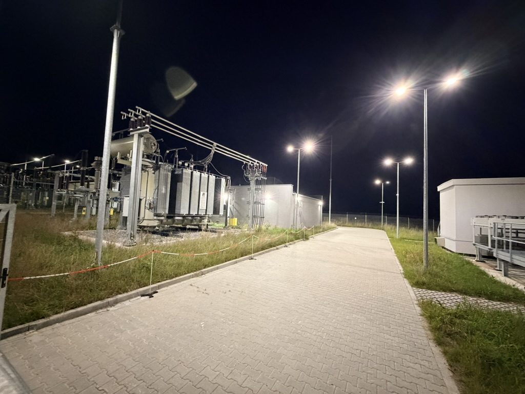 GPO Wysoka Głogowska nocą: oświetlona droga, transformator i budynek stacji